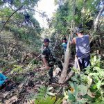 Bersama Masyarakat Desa Ponosakan Indah, Babinsa 1302-12/Belang Bersihkan Rumput Liar di Area Pekuburan